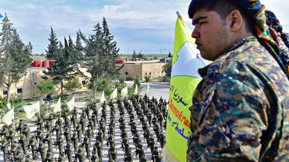 Soldiers of the U.S.-backed, Kurdish-led Syrian Democratic Forces attend a ceremony celebrating victory over the Islamic State on March 23 in the Syrian village of Baghouz.