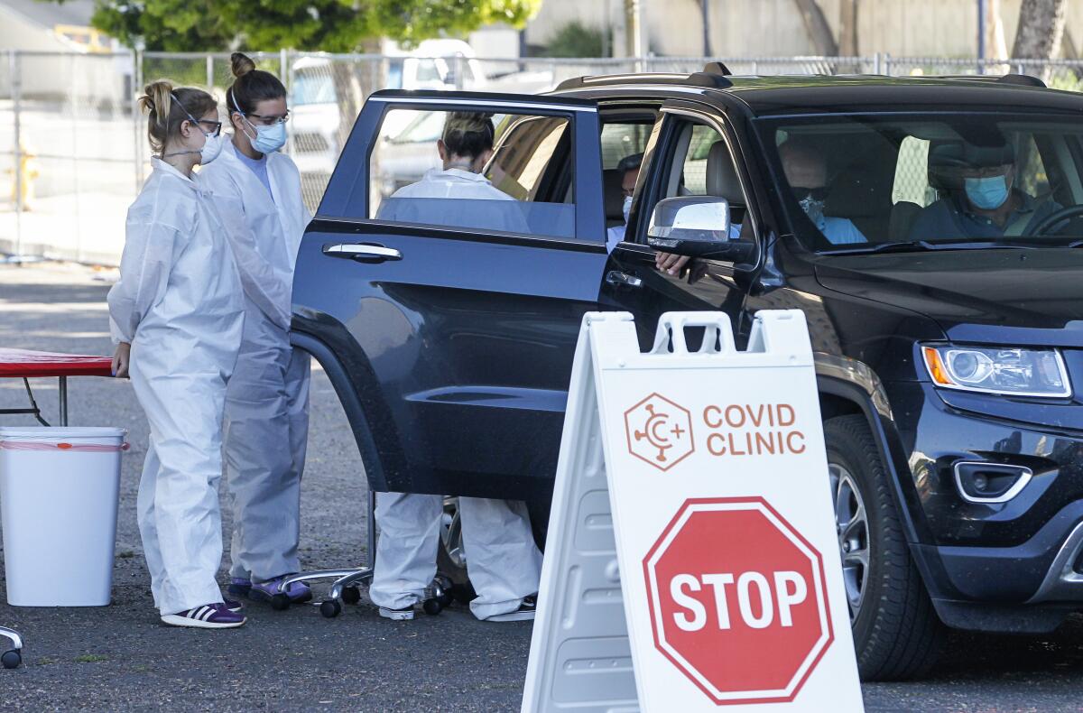 At a COVID-19 testing site in downtown San Diego, registered nurses draw blood from a person for an antibody test on April 30.