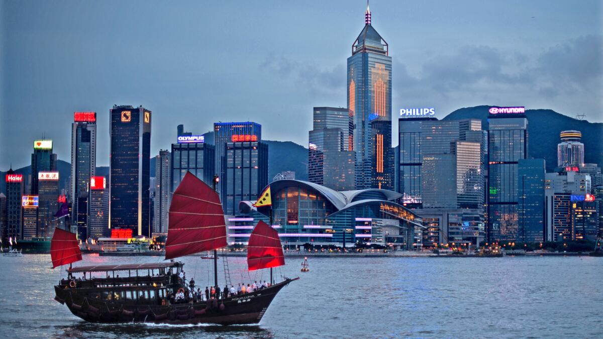 A junk sails on Victoria Harbour in front of the Hong Kong skyline. Air China is offering a $464 round-trip fare from LAX for late summer and fall travel.