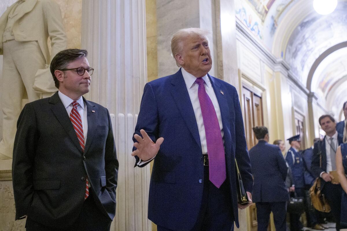 President Trump, with Speaker Mike Johnson, stands in a Capitol hallway.
