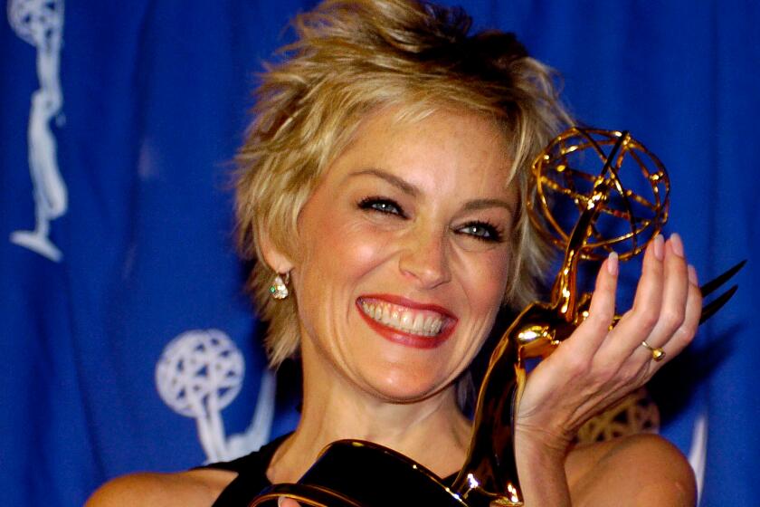 Actress Sharon Stone celebrates with her award after winning Guest Actress in a Drama Series "The Practice,"