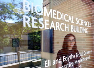 A woman stands inside UCLA's Biomedical Sciences Research building