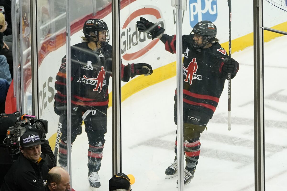 Canada's Marie-Philip Poulin (29) celebrates with Melodie Daquist (15) after scoring the game-winning goal against the United States during the overtime period of a women's exhibition hockey game billed as the "Rivalry Rematch", Saturday, March 12, 2022, in Pittsburgh. (AP Photo/Keith Srakocic)