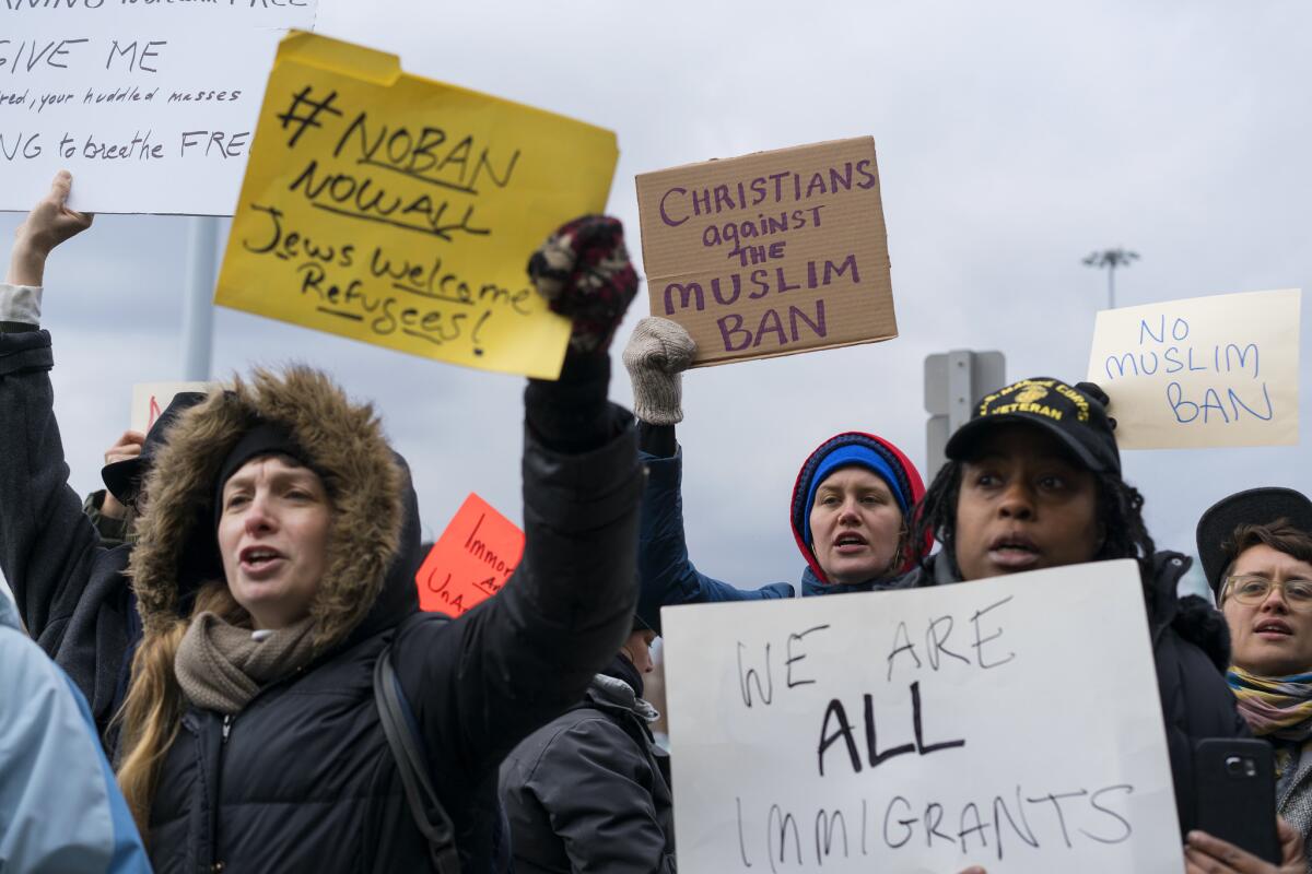 Protesters assemble at John F. Kennedy International Airport in New York after two Iraqis were detained while trying to enter the country.