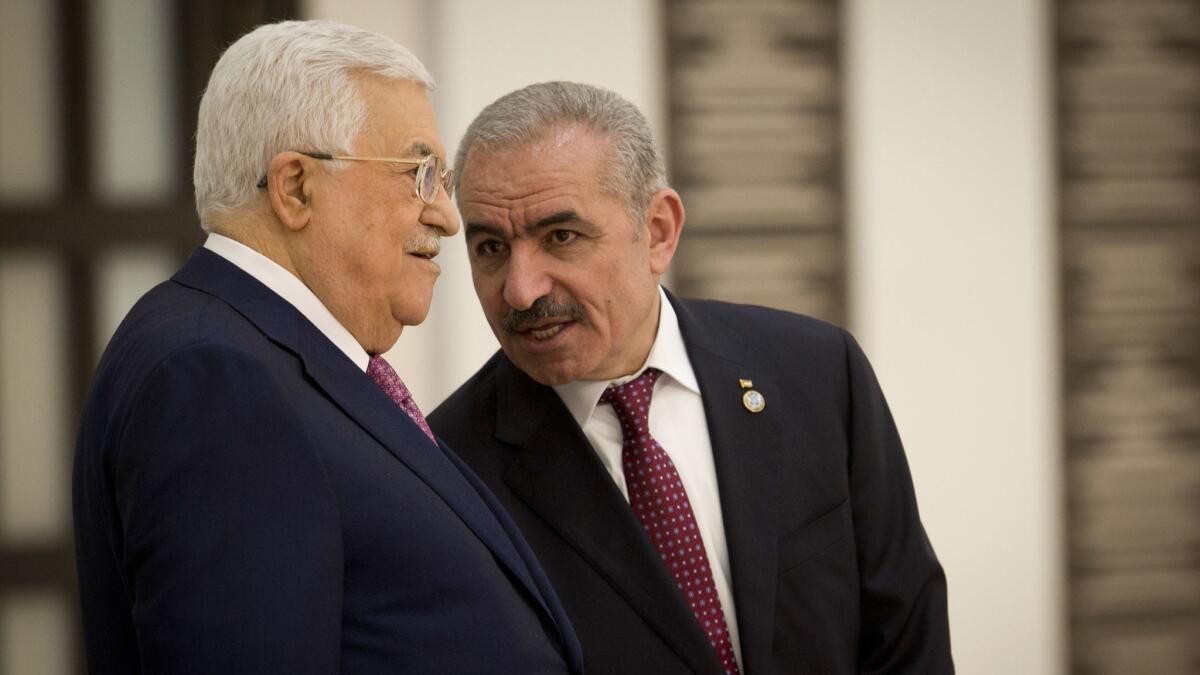 Palestinian Prime Minister Mohammad Ishtayeh, right, talks with Palestinian President Mahmoud Abbas during a swearing in of the new government in the West Bank city of Ramallah on Saturday.