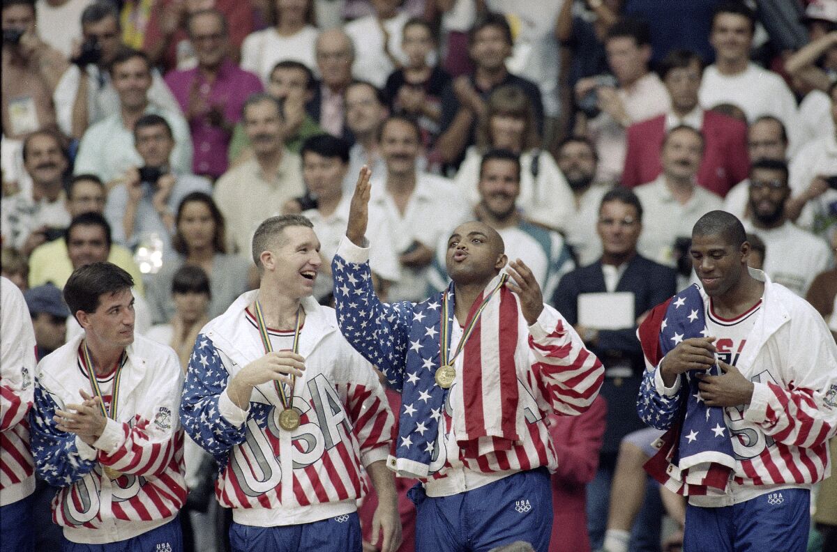 FILE - This Aug. 8, 1992, file photo shows, from left, USA's John Stockton, Chris Mullin, Charles Barkley and Magic Johnson rejoicing with their gold medals after beating Croatia 117-85 at the Summer Olympic Games in Barcelona. (AP Photo/John Gaps III, File)