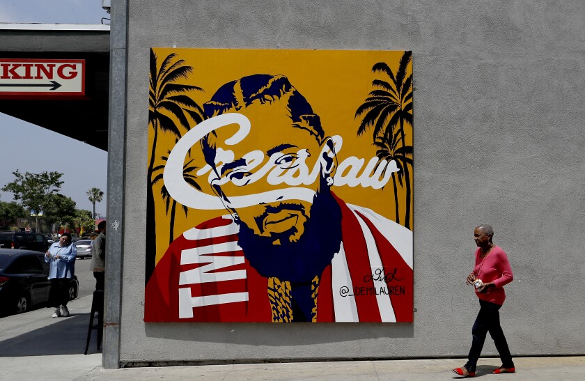 A mural of Nipsey Hussle depicts him with the word "Crenshaw" across his face.