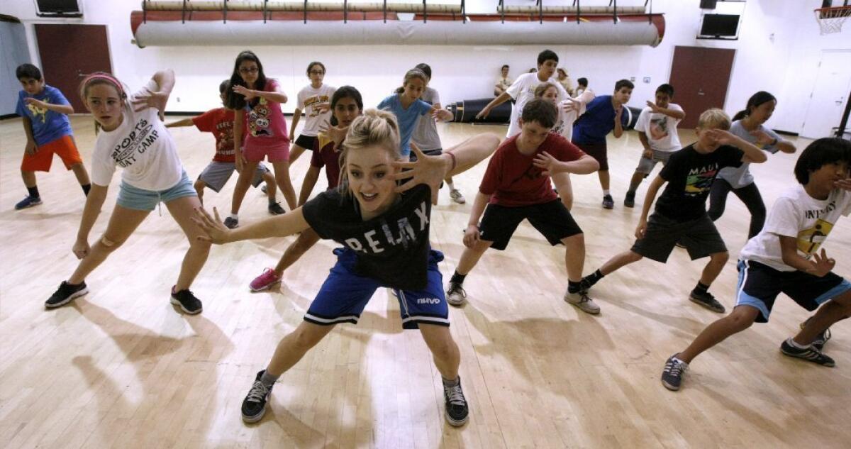 Hip-hop dance instructor Kelli Erdmann, center, goes through a routine with Spartan All-Stars All-Sports Campers at La Cañada High.