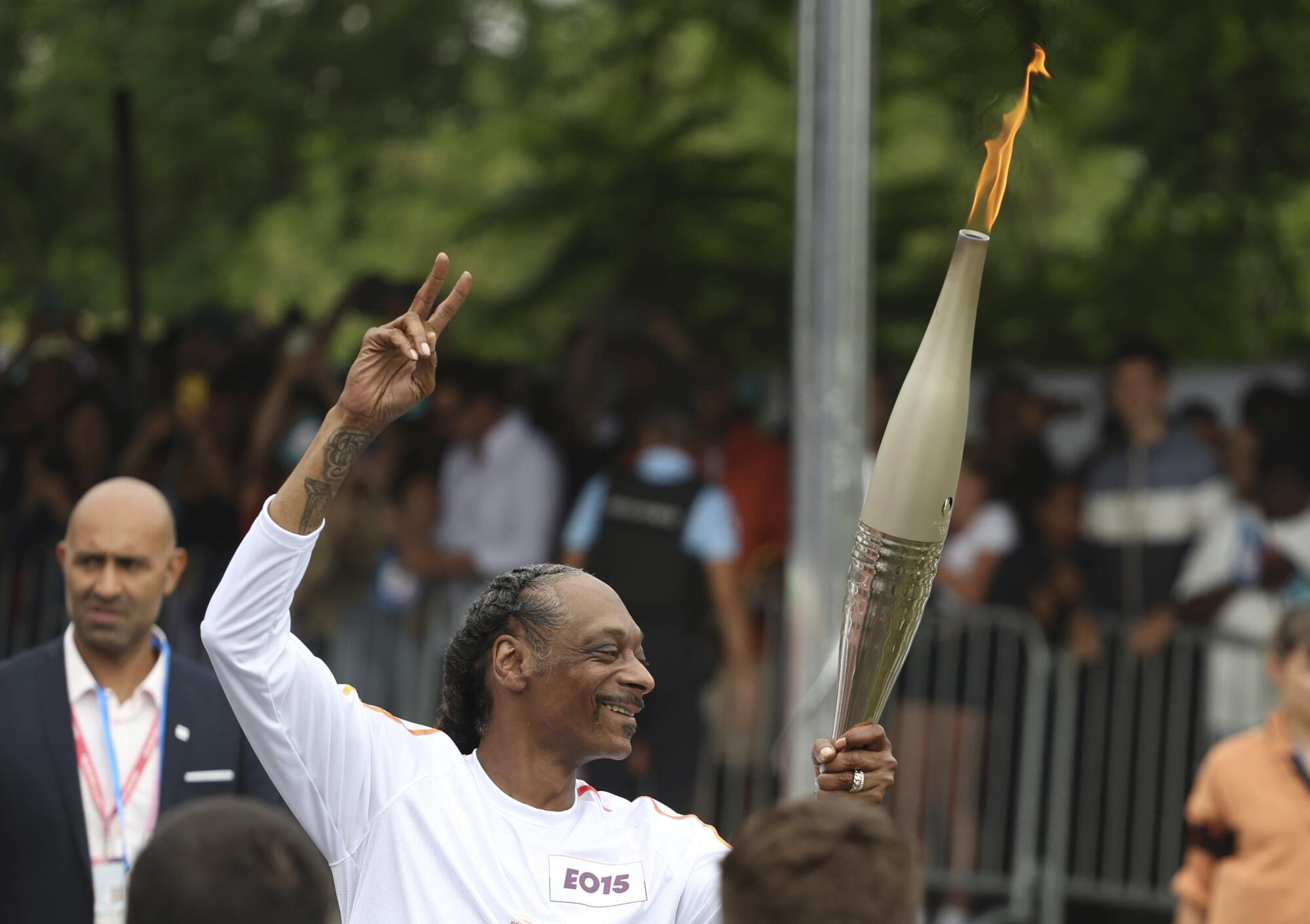 Snoop Dogg carries the Olympic torch at the 2024 Summer Olympics.