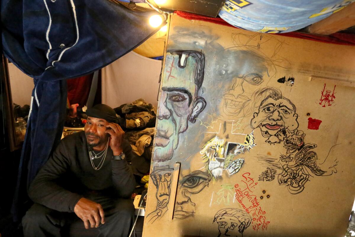 A man sits inside his makeshift home.