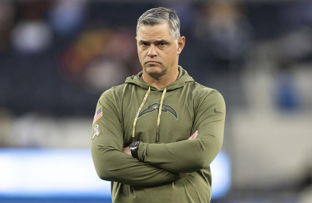 Chargers offensive coordinator Joe Lombardi watches players warm up before a game.