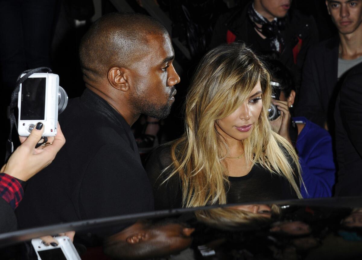 Kanye West and Kim Kardashian depart a showing of Givenchy's ready-to-wear spring/summer 2014 fashion collection in Paris.