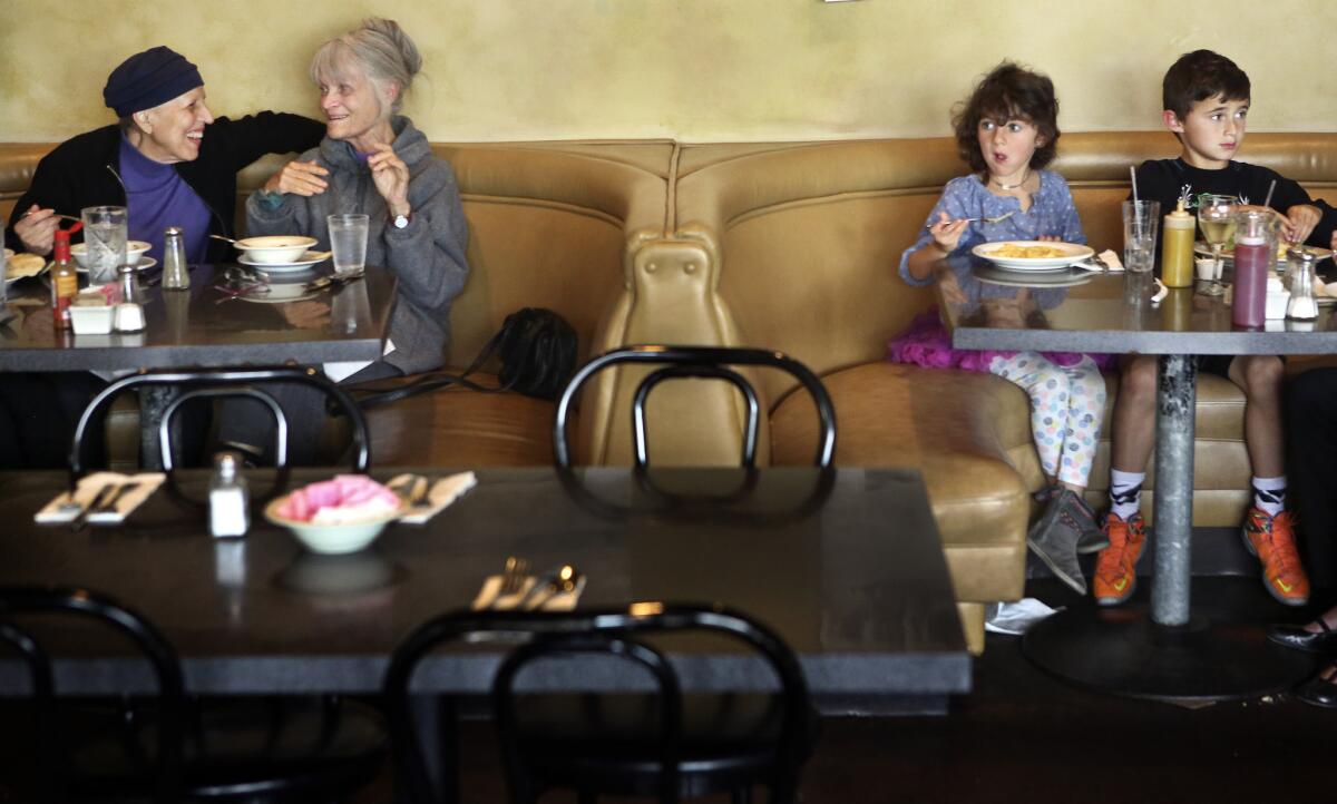 Kit Kollen, left, and friend Susan Romo enjoy each others company and a bowl of soup, while Coco Carson, 5, has macaroni and cheese as her brother Nicolas, 8, dines on a bacon cheeseburger at Victor's Square Restaurant on Bronson Avenue in Hollywood on April 23. The restaurant closed last month.