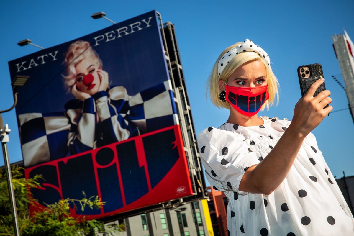 Katy Perry takes a selfie with a billboard promoting her new album “Smile,” near her record label, Capitol Records.