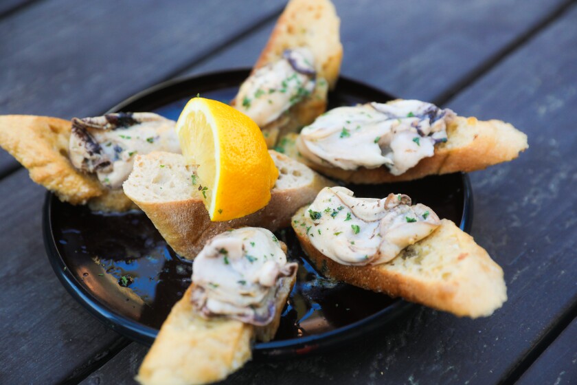 Baguette slices are topped with oysters.