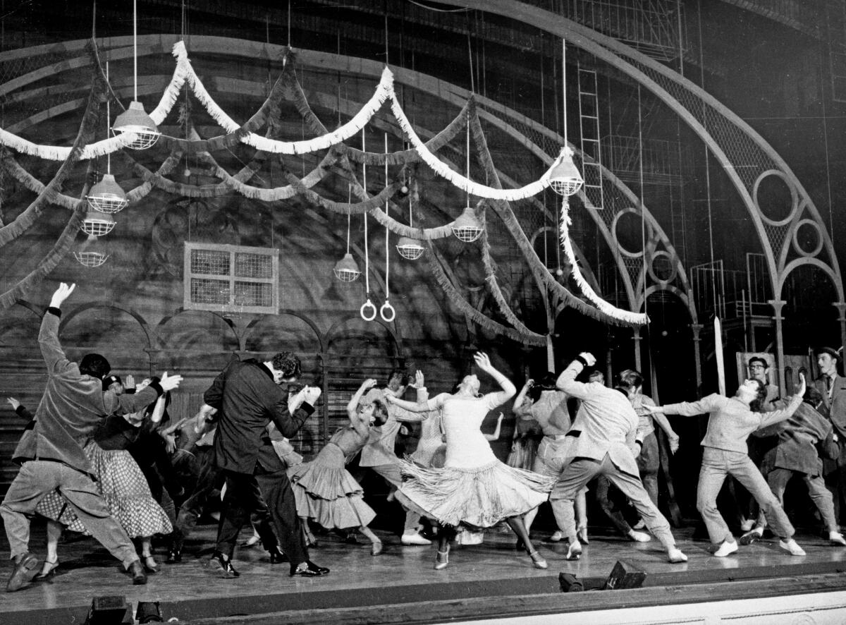 Men and women dance on a stage.