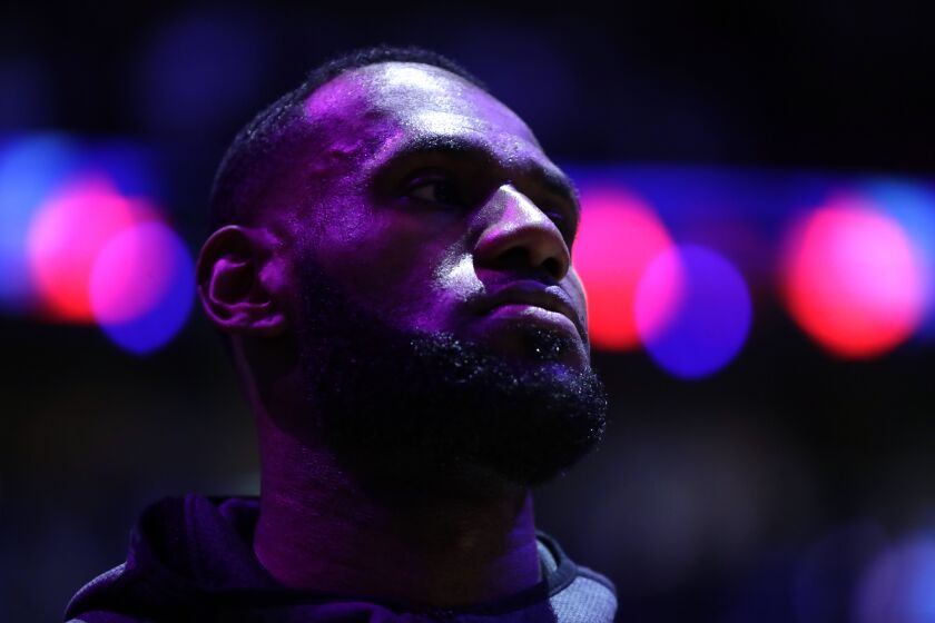 Los Angeles Lakers forward LeBron James stands for the national anthem during the first half of an NBA basketball game against the Miami Heat, Friday, Dec. 13, 2019, in Miami. (AP Photo/Lynne Sladky)