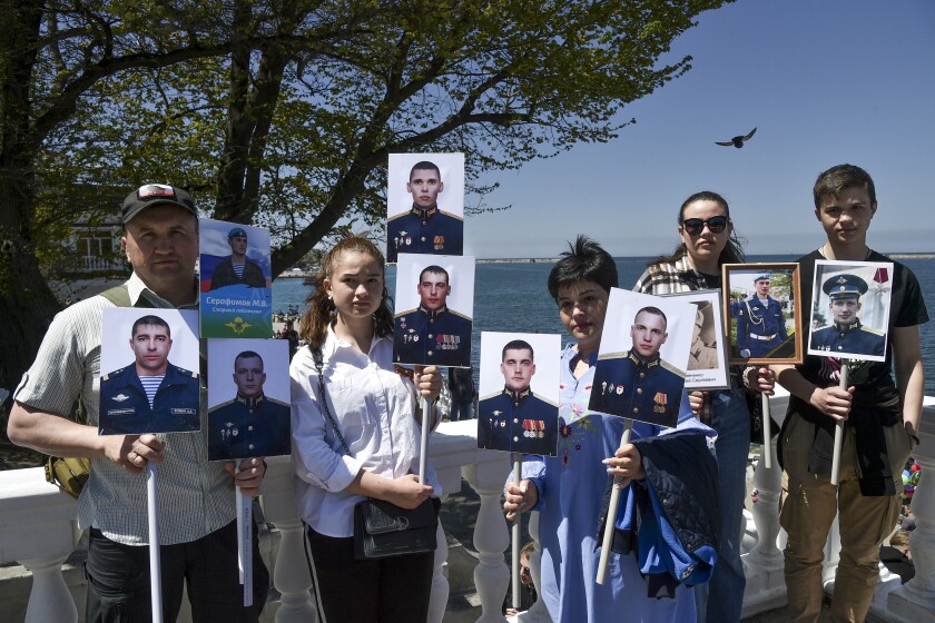 People holding portraits of Russian soldiers killed in Ukraine