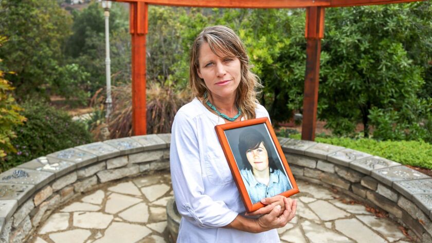 Katharine Prescott holds a photo of her late son, Kyler, standing in a memorial garden created in his memory at the family's home in Vista.