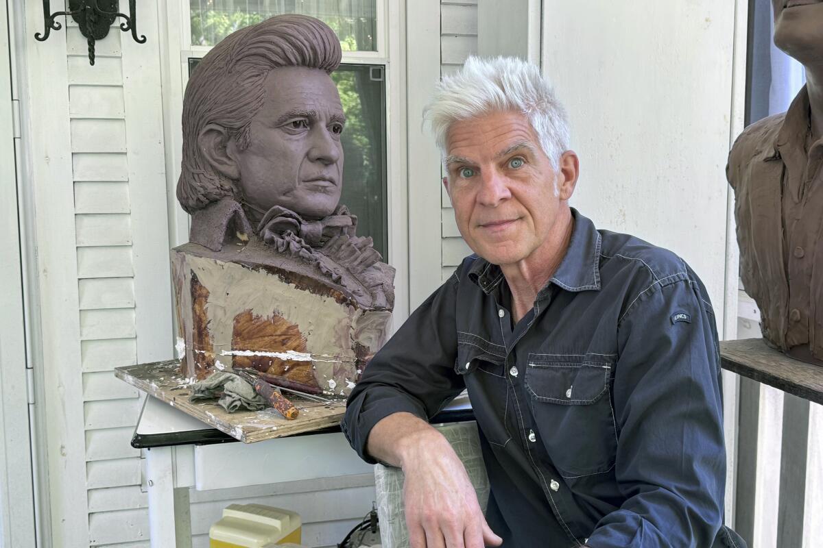 Artist Kevin Kresse is shown with a clay bust of Johnny Cash.