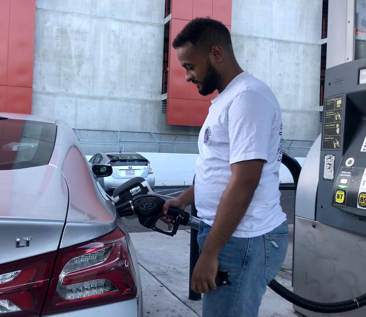 Ermias Yohannes of East Village fills up his car at a Petromerica station. 