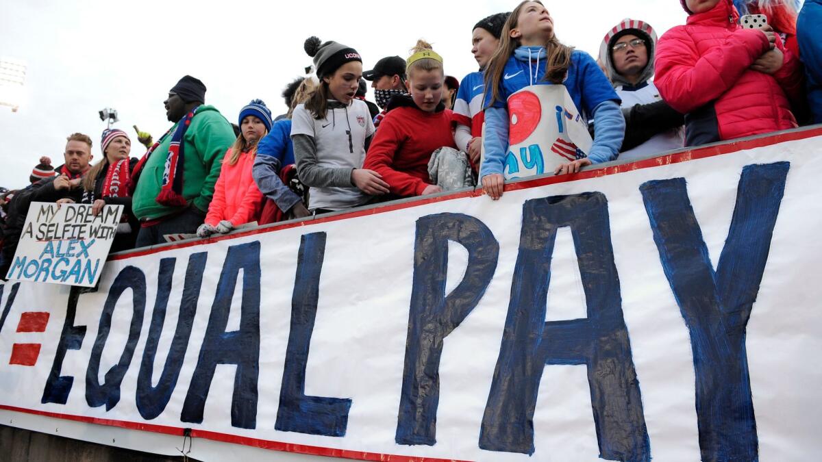 Fans push for equal pay for the women's soccer team during an international friendly soccer match between the United States and Colombia in East Hartford, Conn., in April 2016.