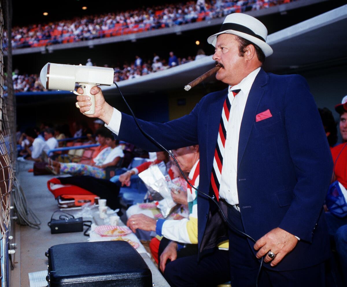 Dodgers scout Mike Brito is seen in his familiar position at Dodger Stadium, behind home plate with radar gun in hand.