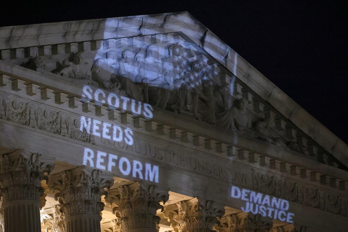 An upside-down flag and demands for change projected onto the Supreme Court building 