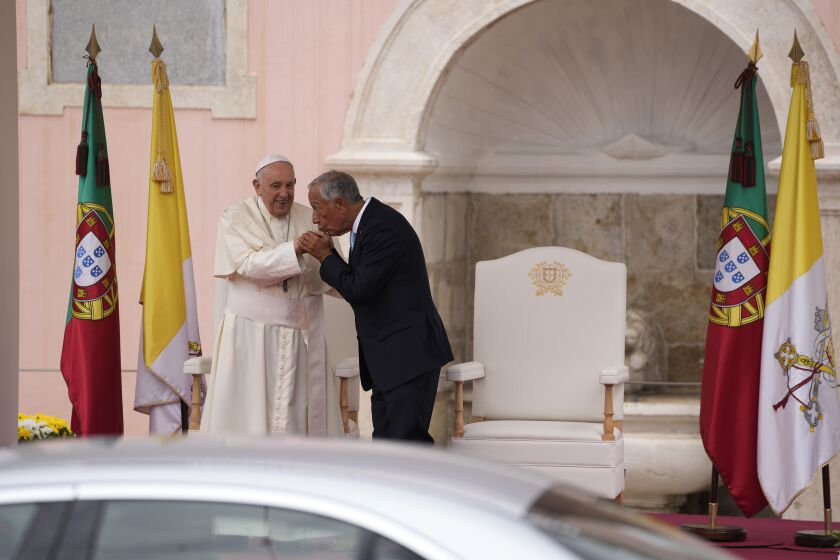 El presidente de Portugal, Marcelo Rebelo de Sousa, a la derecha, besa la mano del papa Francisco durante la ceremonia de recepción del pontífice en el palacio presidencial de Belén, en Lisboa, el miércoles 2 de agosto de 2023. (AP Foto/Armando Franca)