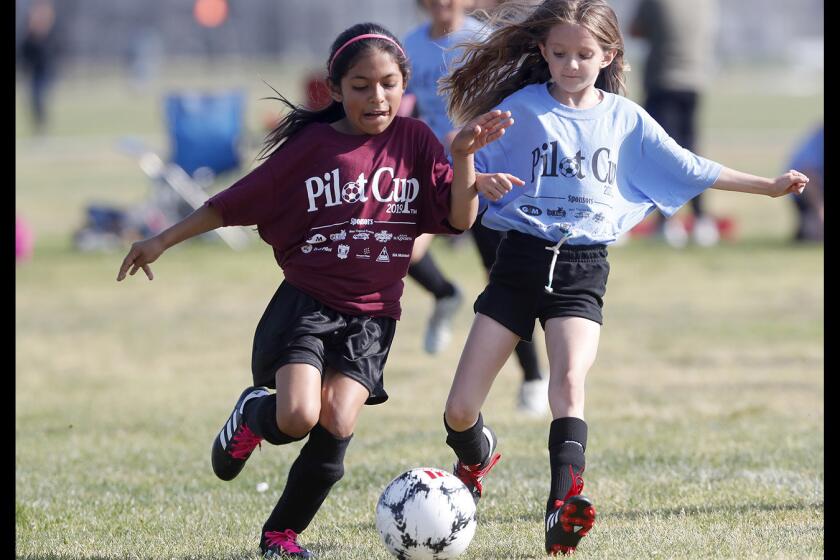 Costa Mesa Sonora Elementary's Natalie Hernandez, left, steals the ball from Costa Mesa California's Amelia Zuniga in a girls' third- and fourth-grade Bronze Division pool-play match at the Daily Pilot Cup on Thursday at Costa Mesa High.