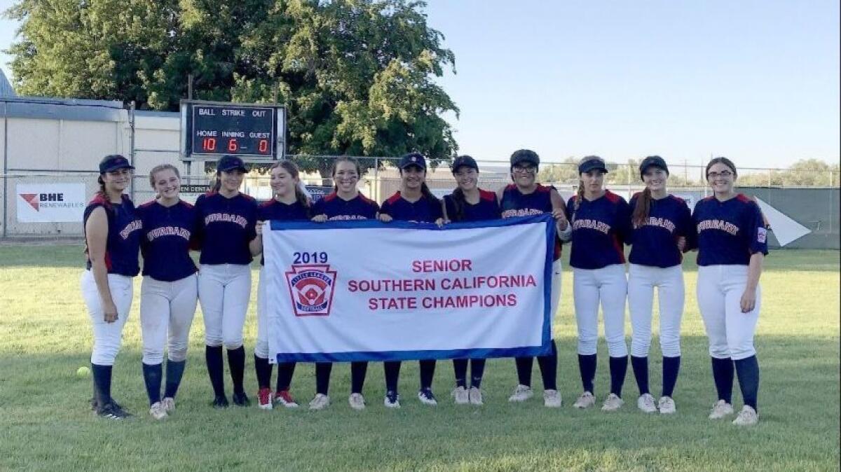 Members of the Burbank senior Little League All-Star softball team hold up their state championship banner after beating Los Angeles, 10-0, on July 10.