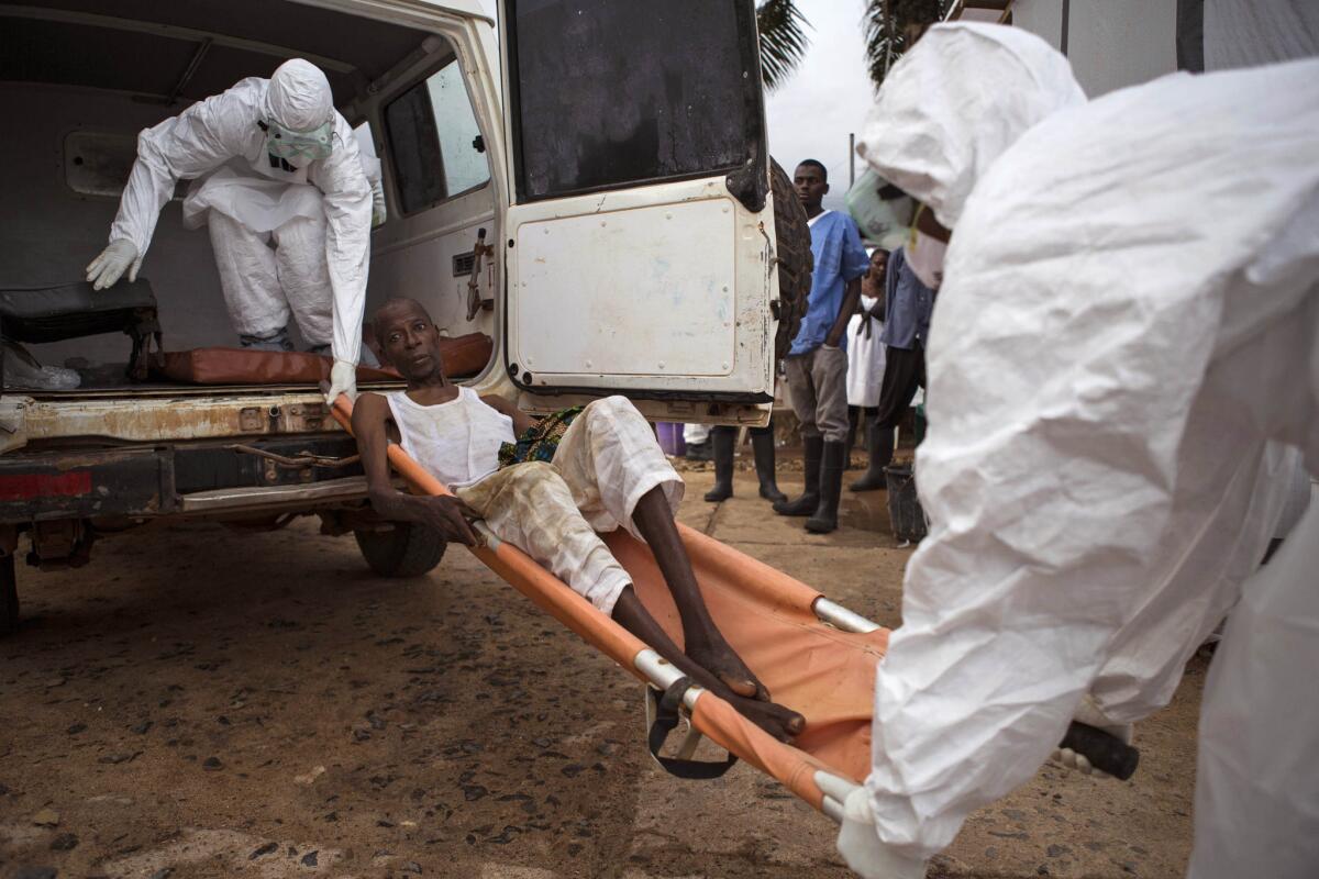 Healthcare workers load a man suspected of suffering from Ebola into an ambulance in Kenema, Sierra Leone, on Sept. 24
