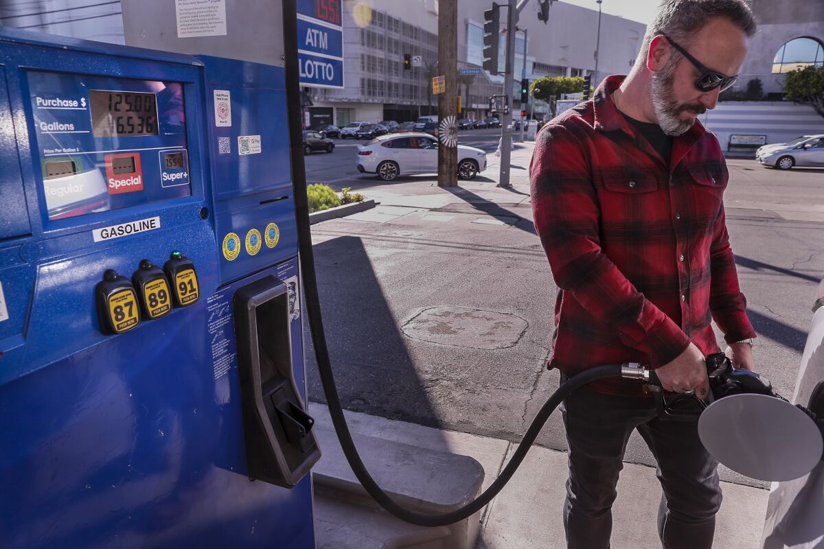 Jesse Espersen of Topanga fills his SUV at a Mobil station near Beverly Center.