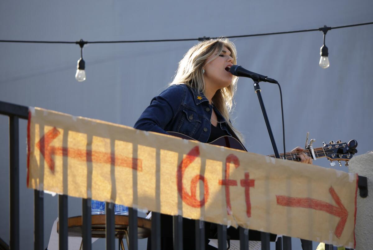 With a large social distancing sign in front of her, Brennley Brown, 18, performs on May 22.