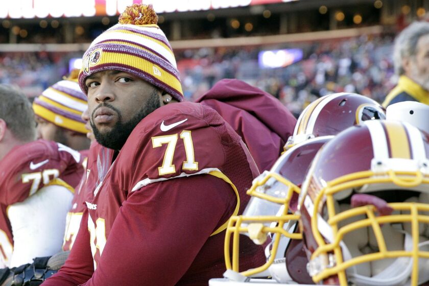 In this photo taken Dec. 7, 2014, Washington Redskins tackle Trent Williams (71) watches the action from the bench during the first half of an NFL football game against the St. Louis Rams in Landover, Md. The Redskins are 0-4 on the road this season, part of an eight-game losing streak away from home that dates to last season. In contrast, they're 4-1 at home this season, including four victories in a row. (AP Photo/Mark Tenally)
