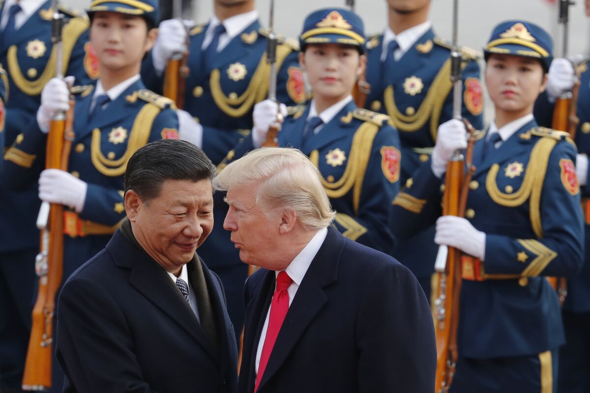 Chinese President Xi Jinping chats with President Trump during his visit to Beijing in 2017.