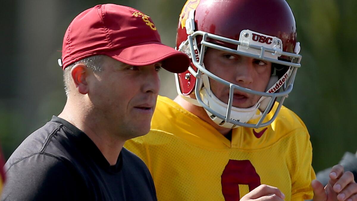 USC offensive coordinator Clay Helton works with quarterback Cody Kessler during a team practice session in October 2013.