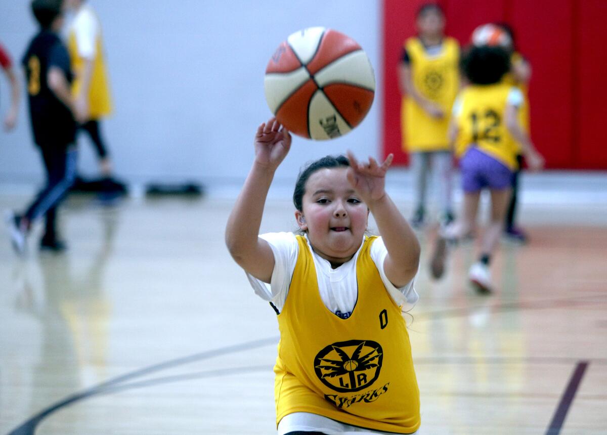 Aisha Navel, 9 of Burbank, throws the ball to a teammate while participating in the L.A. Sparks & DEA 360 basketball clinic at the YMCA in Burbank on Wednesday, Feb. 12, 2020.