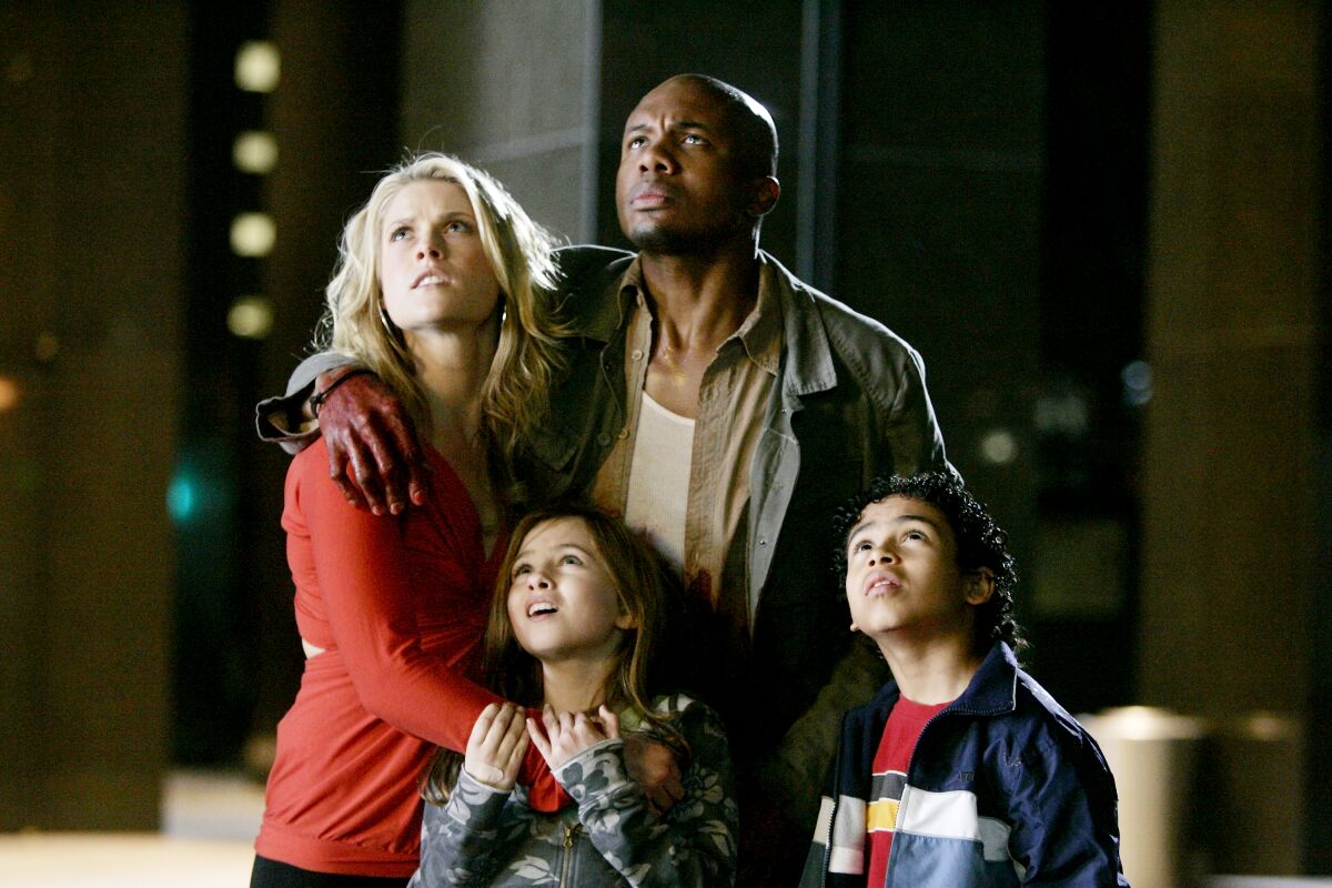 Ali Larter and Leonard Roberts in a scene from "Heroes," with two child actors