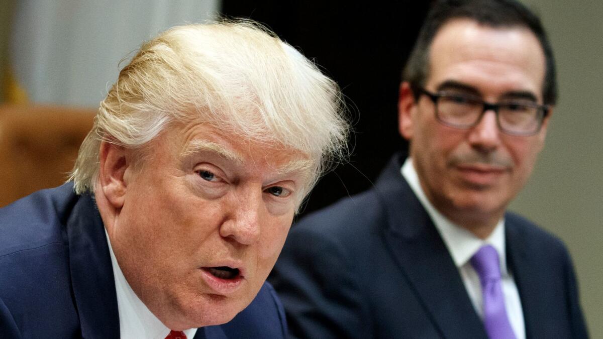 Treasury Secretary Steven Mnuchin listens at right as President Donald Trump speaks during a meeting on the Federal budget in the Roosevelt Room of the White House on Feb. 22.
