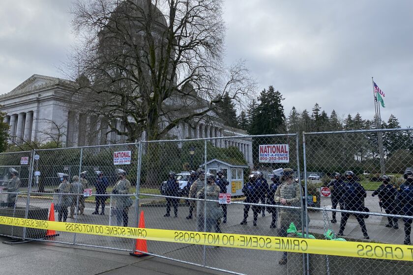 National Guard troops backed by state troopers guard the Washington state Capitol in Olympia Sunday.