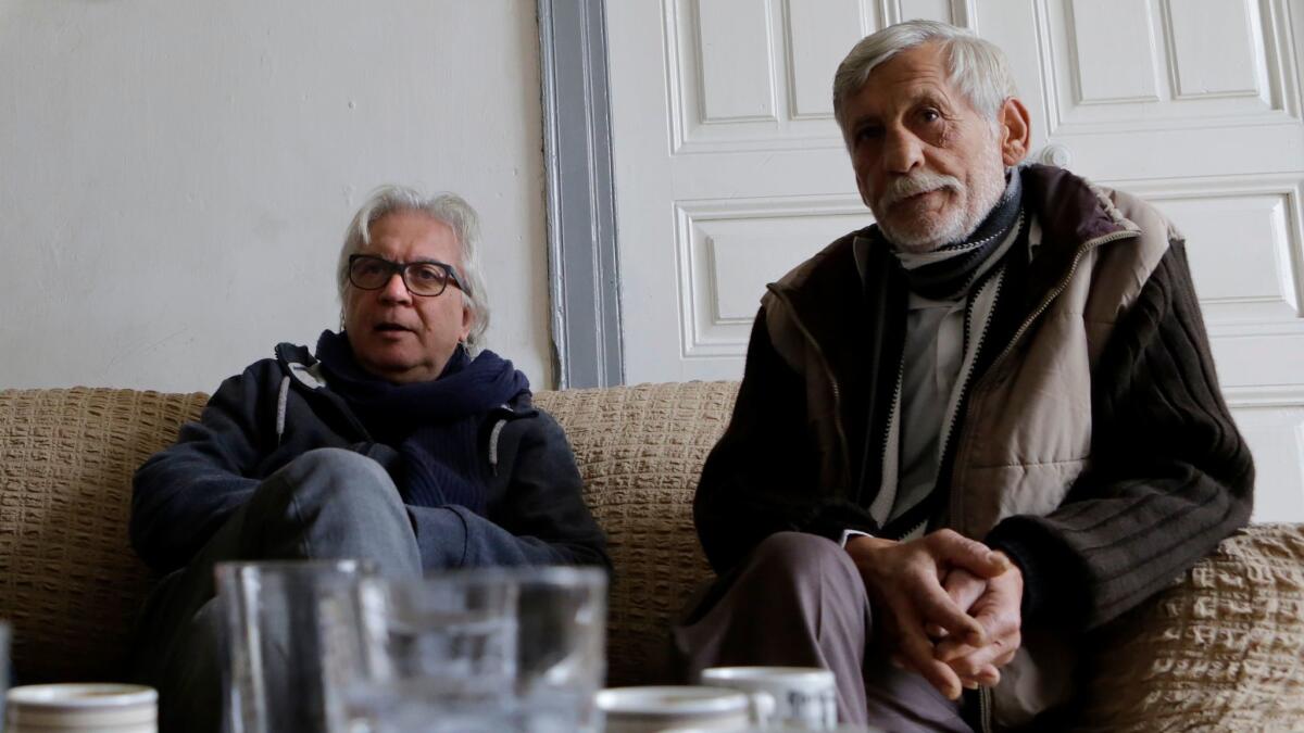 Greek Cypriot Michalis Georgiades, left, and Turkish Cypriot Cumar Kamir sit and talk in the mud-brick house in Morphou that is the foundation of their friendship.