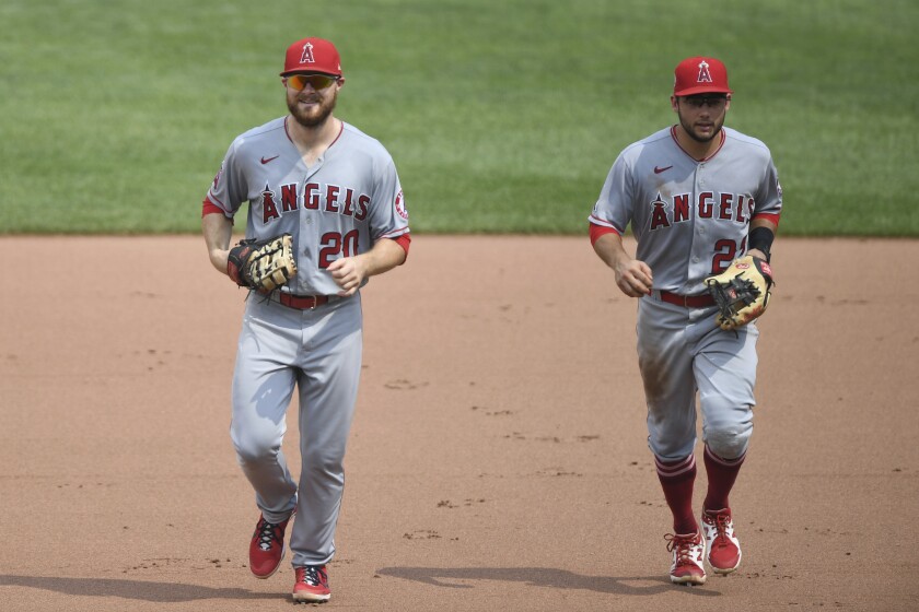 Angels first baseman Jared Walsh and second baseman David Fletcher jog off the field.