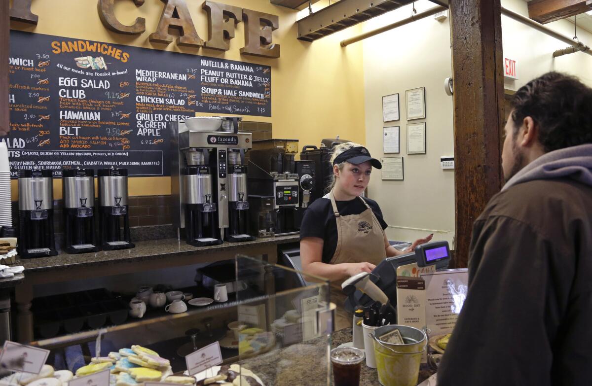 Kayla Mitchell serves a customer at Good Day Cafe in North Andover, Mass., in March.