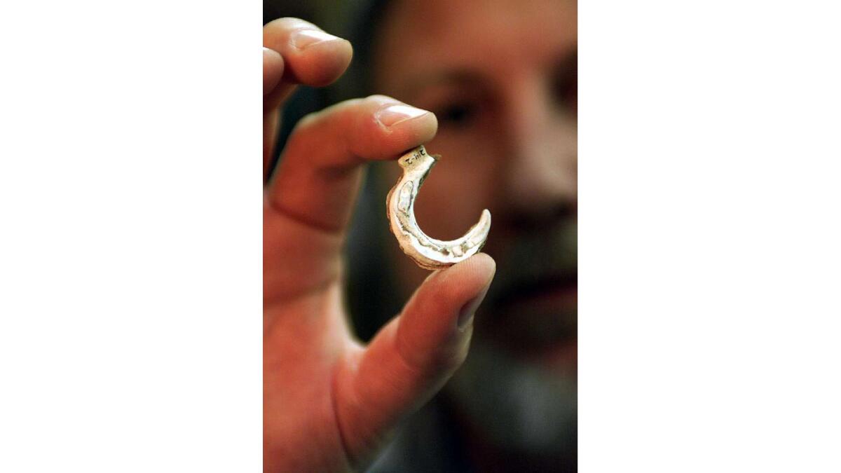 Archeologist Steve Scwhartz holds a fishhook made of abalone found on San Nicolas Island off the California coast.