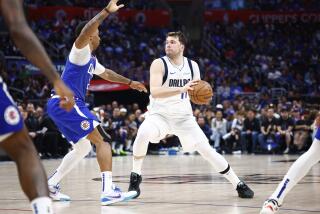 Dallas Mavericks star Luka Doncic, right, controls the ball during the Clippers' Game 1 win at Crypto.com Arena on Sunday.