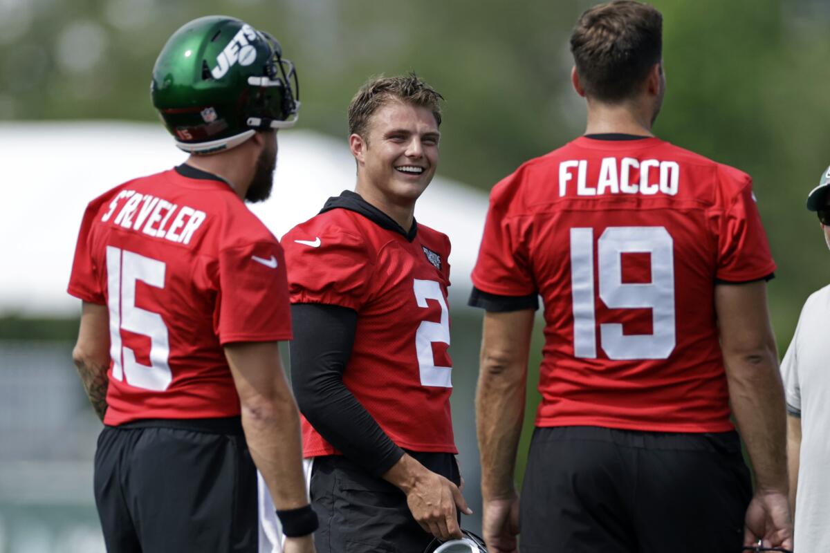 New York Jets quarterback Zach Wilson (2) laughs with quarterbacks Joe Flacco (19) and Chris Streveler during a break in drills at the NFL football team's practice facility in Florham Park, N.J., Thursday, July 28, 2022. (AP Photo/Adam Hunger)