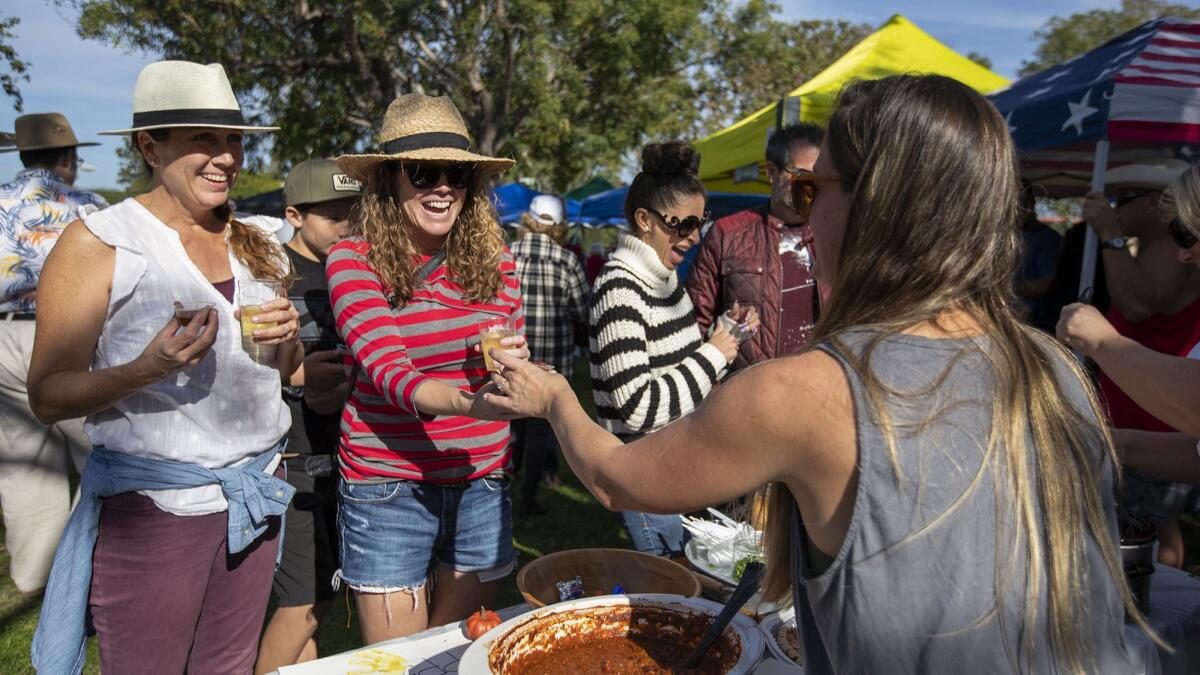 Tricia Wilkinson, right, offers a taste of her “Momma's Chili” to Megan Pisciotti, left, and Shannon Quinnduring the annual Halecrest Park Chili Cook Off on Saturday.