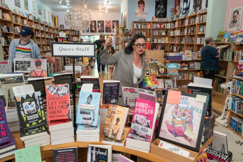 SAN FRANCISCO CA JUNE 17, 2024 - Becka Robbins, manager at Fabulosa Books in the Castro District, picks out books to fill a box for the Books Not Bans program inside the store on Monday, June 17, 2024 in San Francisco, California. Robbins runs a program out of a closet inside the store called Books Not Bans, sending LGBTQ+ books to LGBTQ+ organizations in conservative parts of America. (Loren Elliott / For The Times)
