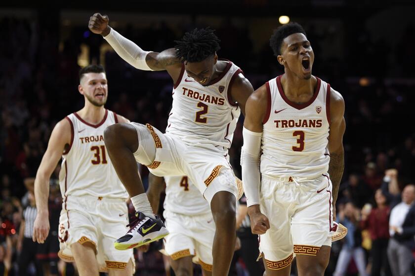 Southern California guard Elijah Weaver, right, celebrates after making a three-point shot to tie the game to force overtime during the second half of an NCAA college basketball game as Jonah Mathews, center, jumps to celebrate against Stanford in Los Angeles, Saturday, Jan. 18, 2020. Southern California won 82-78. (AP Photo/Kelvin Kuo)